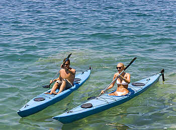 Mumbo Island Camp: Kayakfahrer und traditionelles Fischerkanu Mumbo Island Camp: Kayakfahrer und traditionelles Fischerkanu